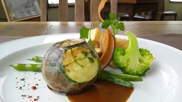 A plate with a rolled meat dish, broccoli, and a sauce.