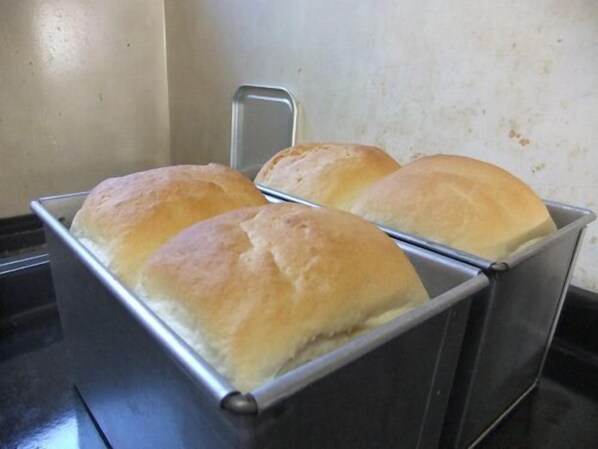 A metal bread box with three loaves of bread. - Pension Restaurant La Collina (Nakafurano)