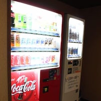 Máquina expendedora con diversas opciones de bebidas, incluyendo Coca-Cola.