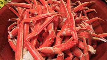 A wooden bowl filled with red crab legs.