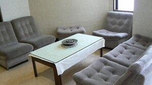 A living room with a sofa set, a coffee table, and a window.