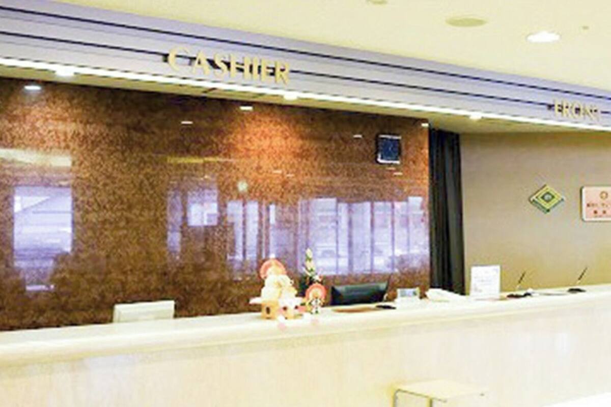 A reception desk with a 'CASHIER' sign, a window, and a door.