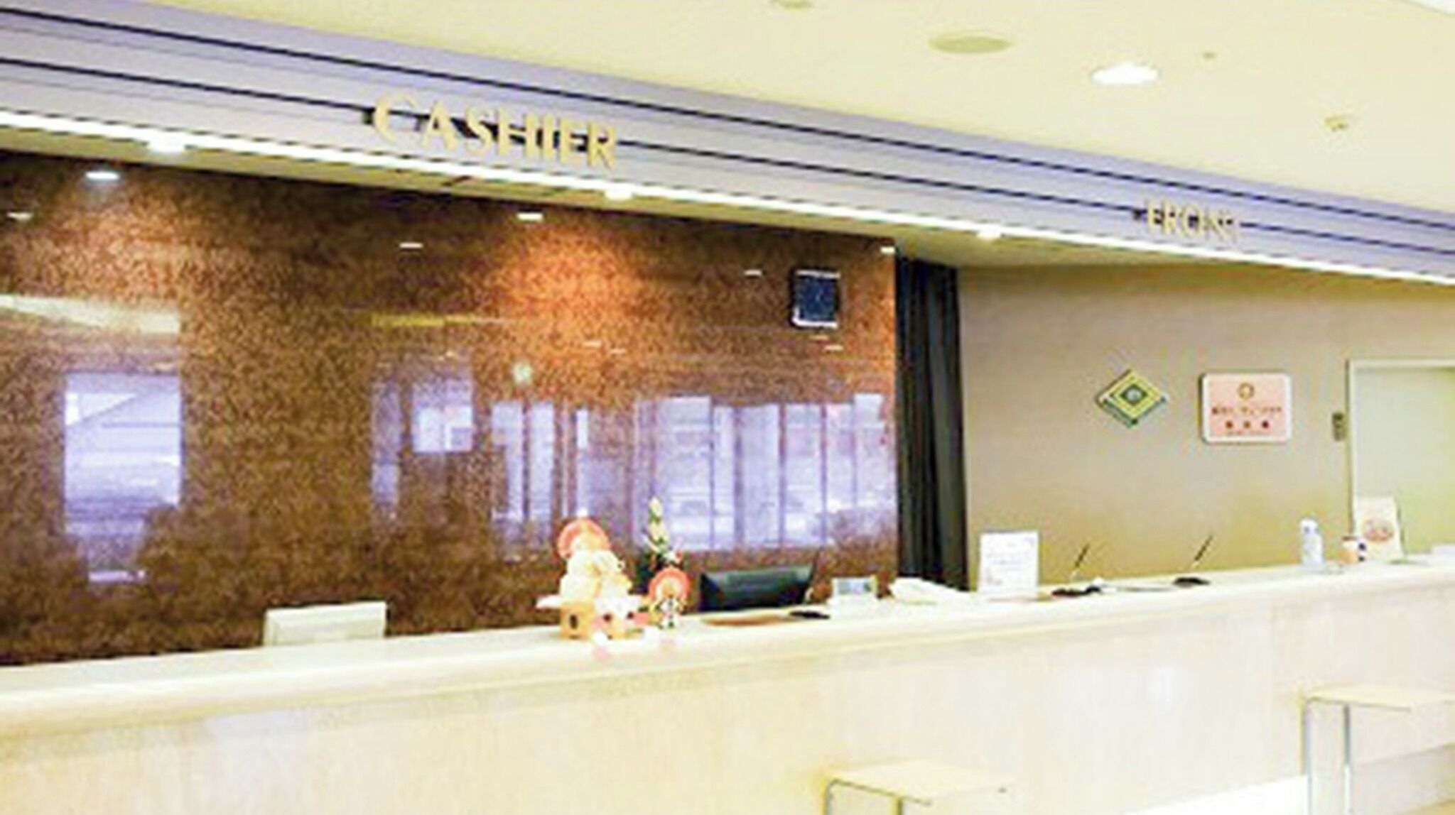 A reception desk with a 'CASHIER' sign, a window, and a door.