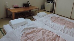 Una habitación de hotel con dos camas, un escritorio, un televisor y un armario.