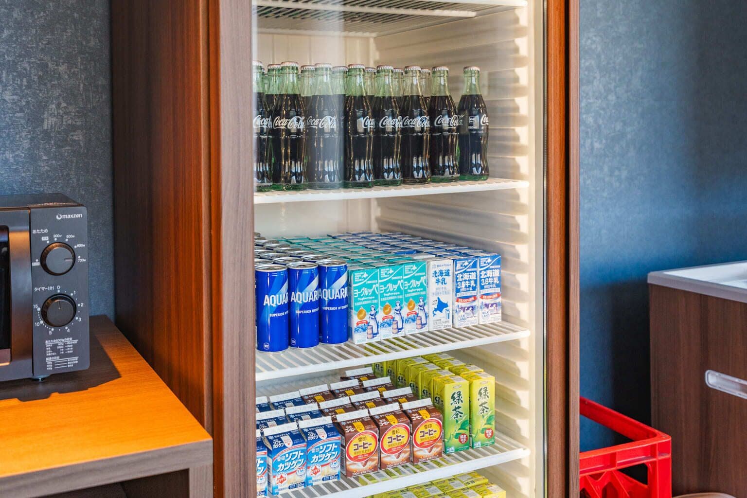 Un refrigerador ple de begudes i aliments, incloent llaunes, ampolles i envasos.