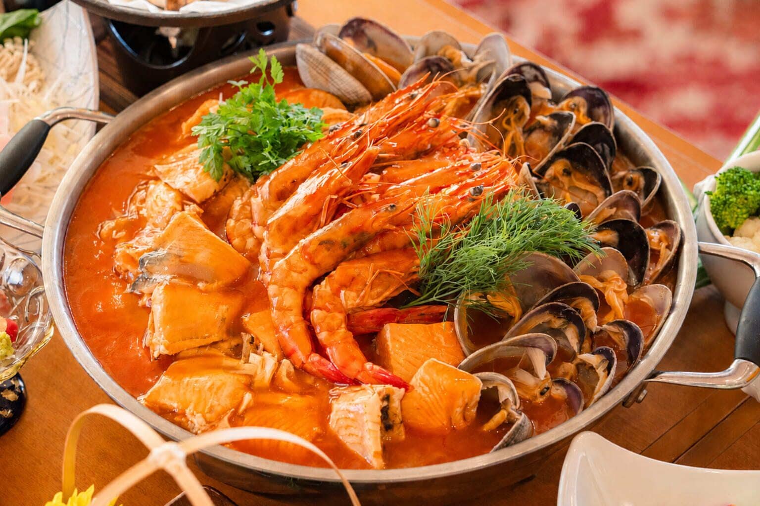 Un plato de mariscos con camarones, mejillones y trozos de pescado en una olla.