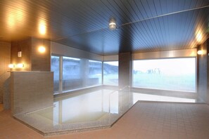 A modern indoor pool area with clear glass walls, a tiled floor, and a ceiling with linear lighting fixtures. - Rembrandt Resort Shiretoko (Shari)