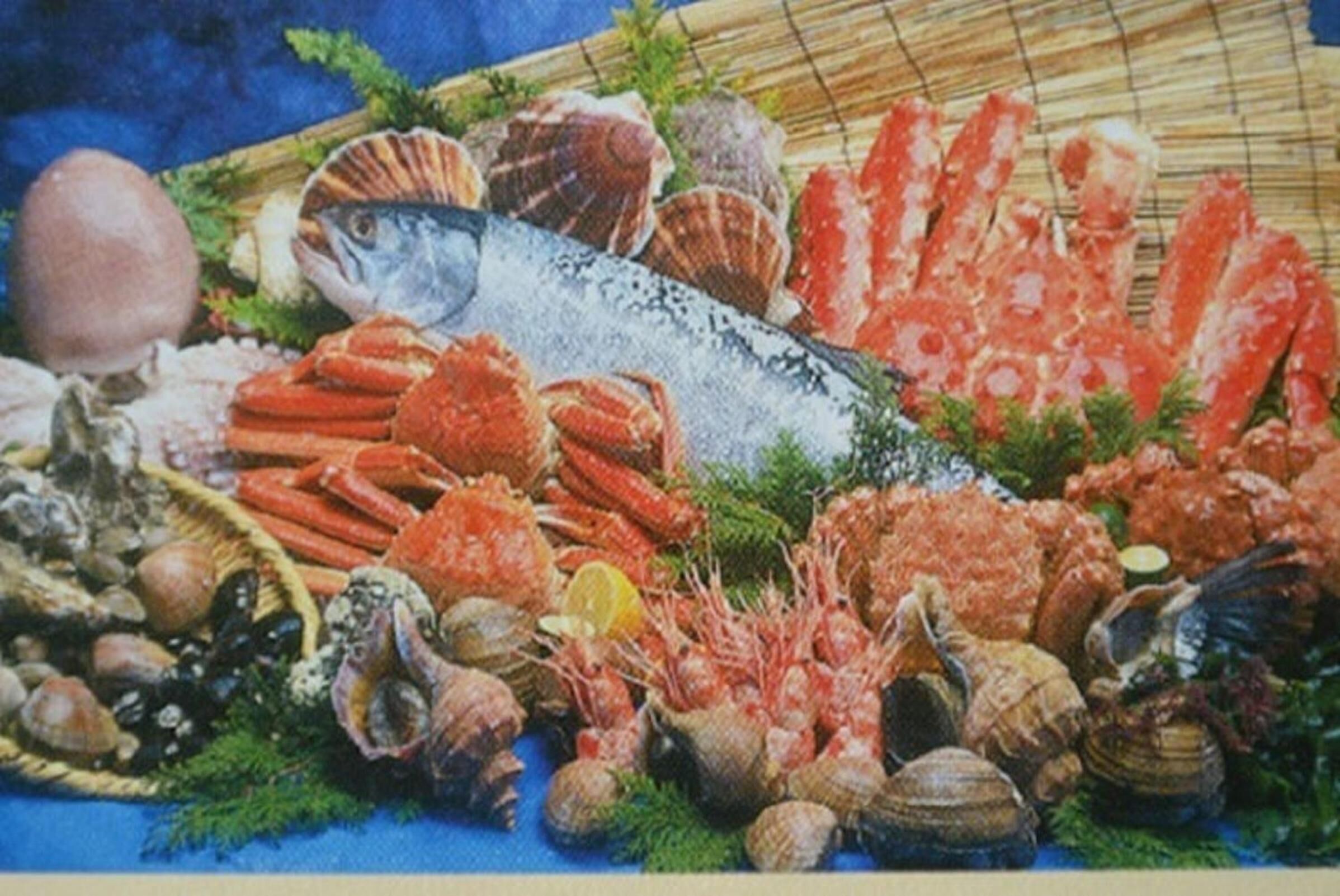 A variety of seafood including fish, shrimp, and clams arranged on a table.