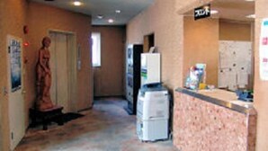 A hallway with a refrigerator, a vending machine, and a poster on the wall. - Business Hotel Motonakano (Tomakomai)