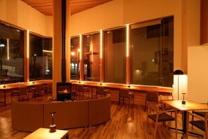 A modern interior with a circular seating area, wooden flooring, and large windows.
