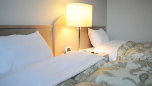 A hotel room with two beds, a bedside table, a lamp, and a clock. - Hotel Sunfuraton (Furano)