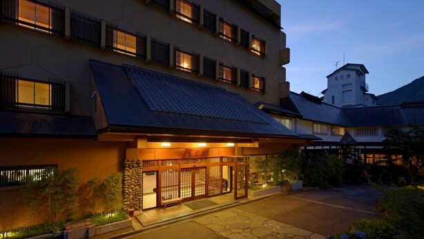 Un hotel de estilo arquitectónico japonés tradicional, con tejado de tejas y puertas de madera.
