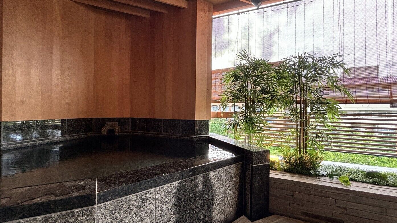 Un área de spa con hidromasaje, paneles de madera y vistas a un edificio a través de una ventana.