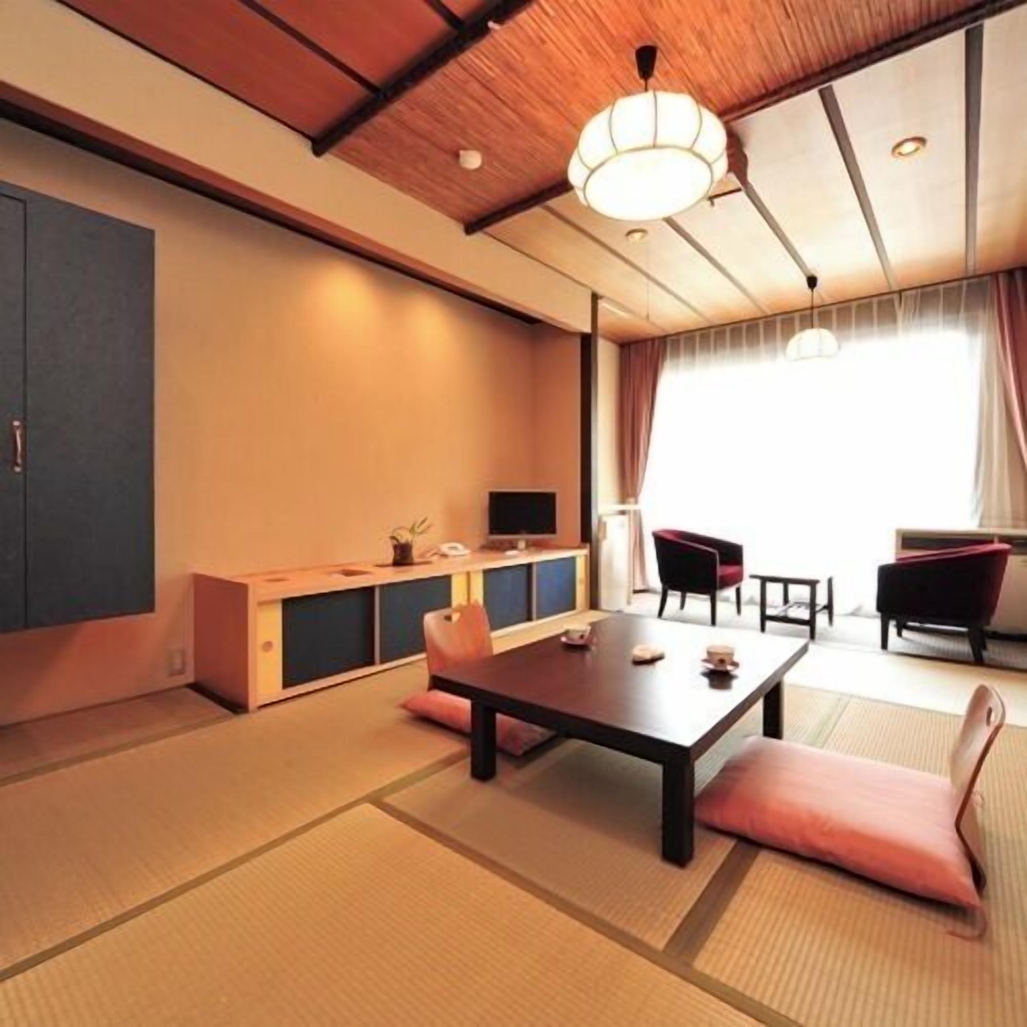 Una habitación japonesa tradicional con suelo de tatami, una mesa baja y un sofá.