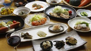 A table with various dishes and a glass of red wine. - Pension ASHITAYA (Furano)