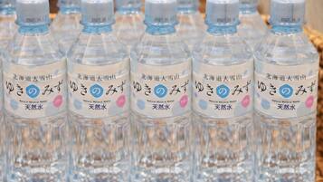 A basket of clear plastic water bottles with labels, arranged in rows.