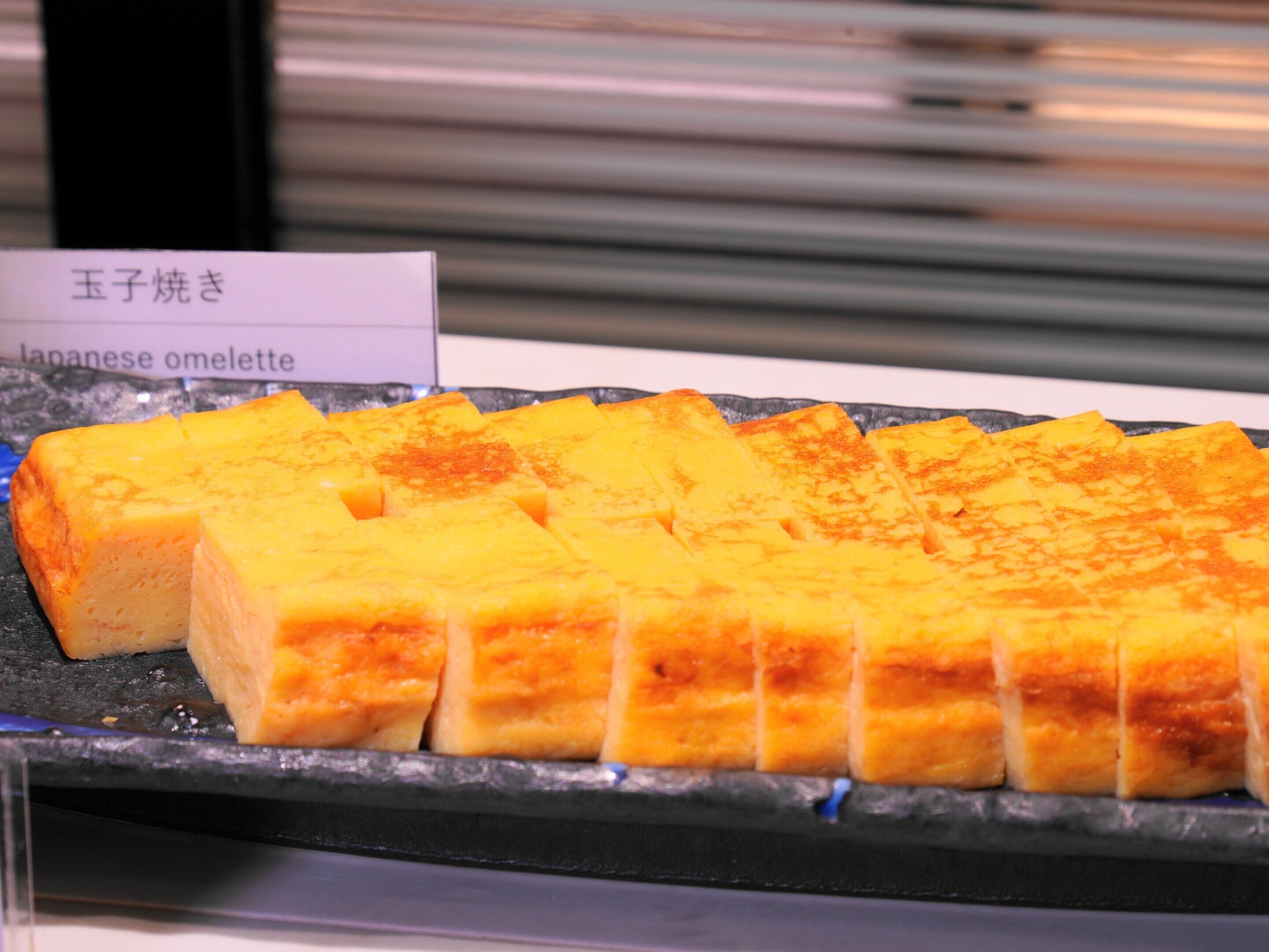 Un omelette japonés sobre un plato negro.