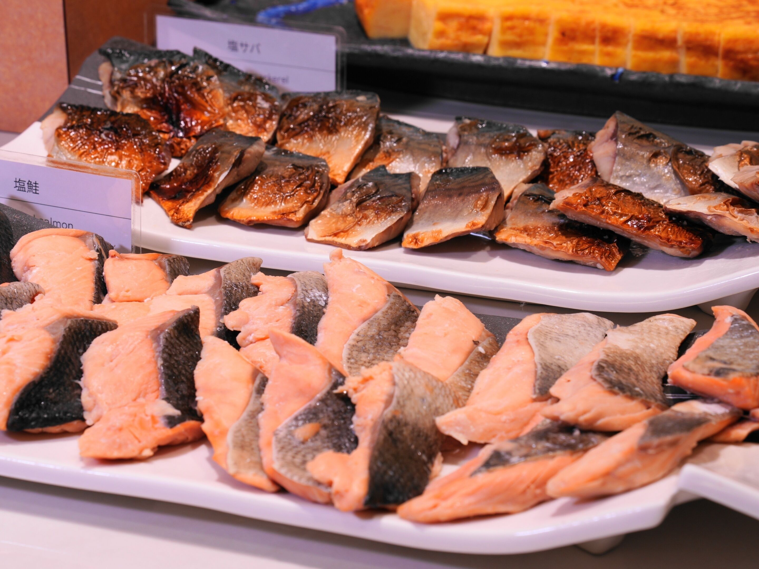 A variety of fish cuts displayed on trays, likely in a market or food preparation area.