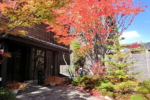 A traditional building with a stone pathway leading to the entrance, surrounded by autumn foliage. - Konoha (Kusatsu)