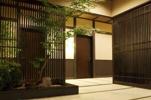 Un interior japonés tradicional con suelo de tatami, puertas correderas y un jardín minimalista.