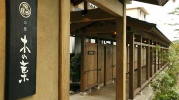 A traditional Japanese building with a wooden exterior and a black sign with white characters.