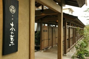 A traditional Japanese building with a wooden exterior and a black sign with white characters.