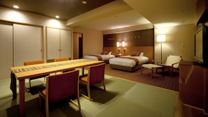 Une chambre d’hôtel équipée d’une table à manger, de deux lits, d’une télévision et d’un bureau.