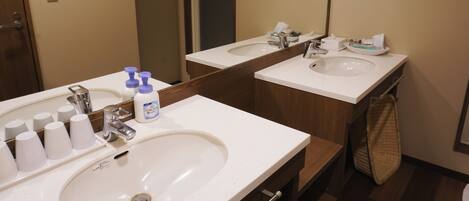A bathroom with two sinks, a mirror, and toiletries.