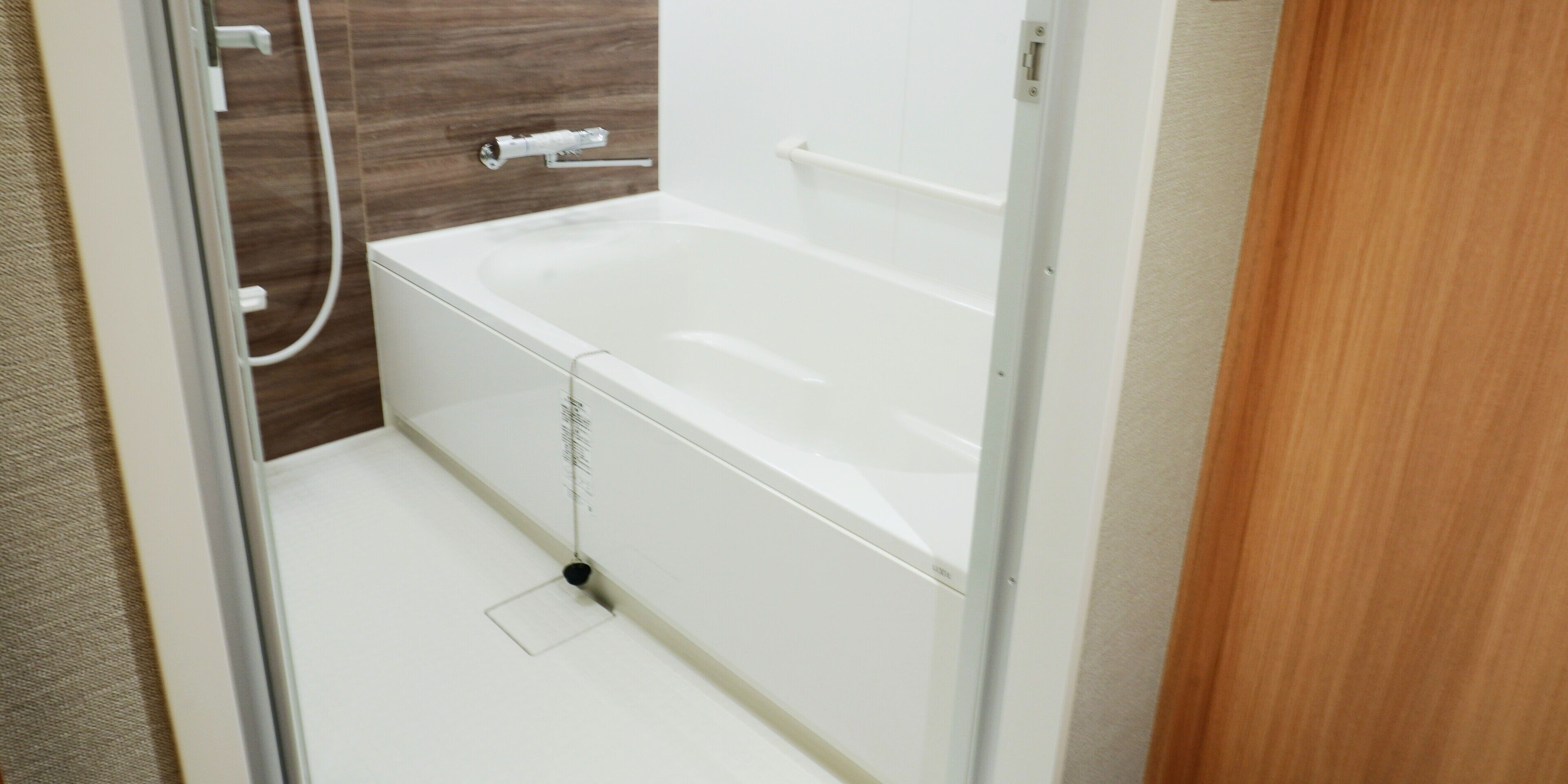 A modern bathroom with a white bathtub, a shower area, and a glass shower door.