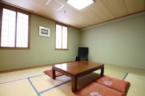A traditional Japanese room with tatami flooring, a low wooden table, and a television. - Wakkanai Sun Hotel (Wakkanai)