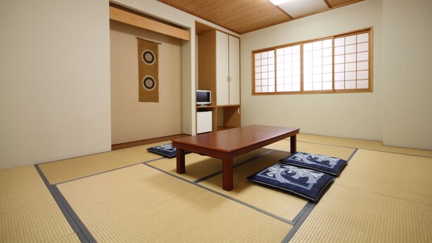 Ein traditioneller japanischer Raum mit Tatami-Böden, einem niedrigen Holztisch und Shoji-Schirmen.