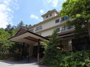 A hotel with a covered entrance, multiple floors, and a garden area. - Okunikko Yumoto Onsen Yumoto Itaya (Nikko)