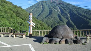 A mountain with a wooden signpost, benches, and a stone structure. - Okunikko Yumoto Onsen Yumoto Itaya (Nikko)
