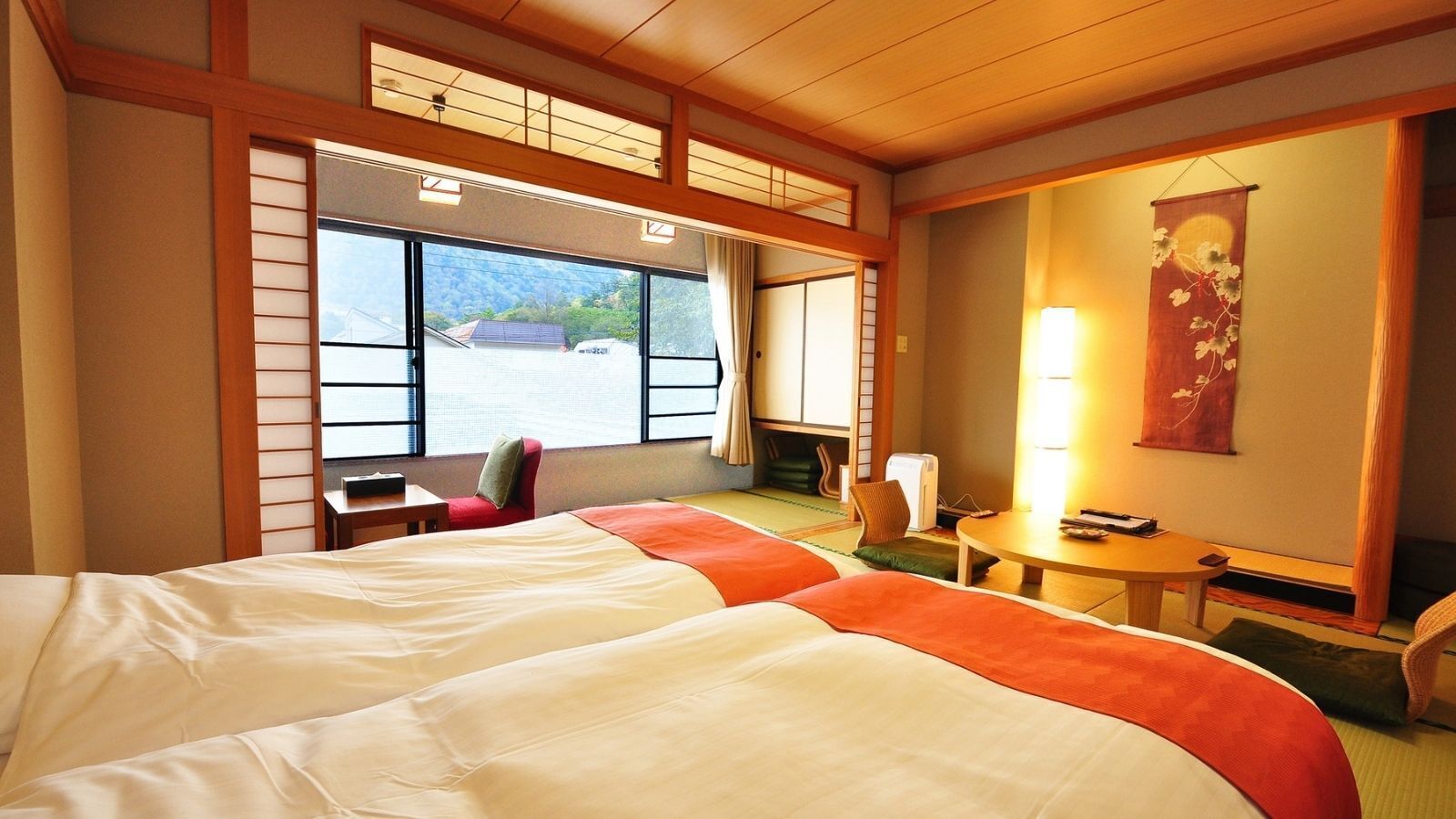 Habitación de hotel con una cama grande, una mesita, una silla y vistas al exterior.