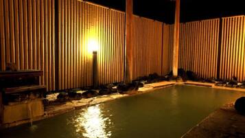 A swimming pool with bamboo walls and a wooden deck.
