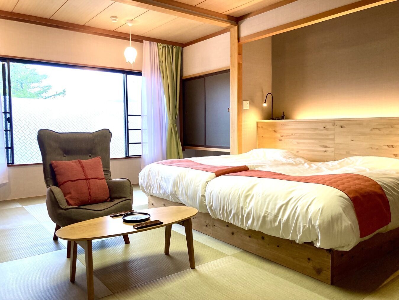 Un dormitorio con una cama, una silla, una mesa y un televisor.