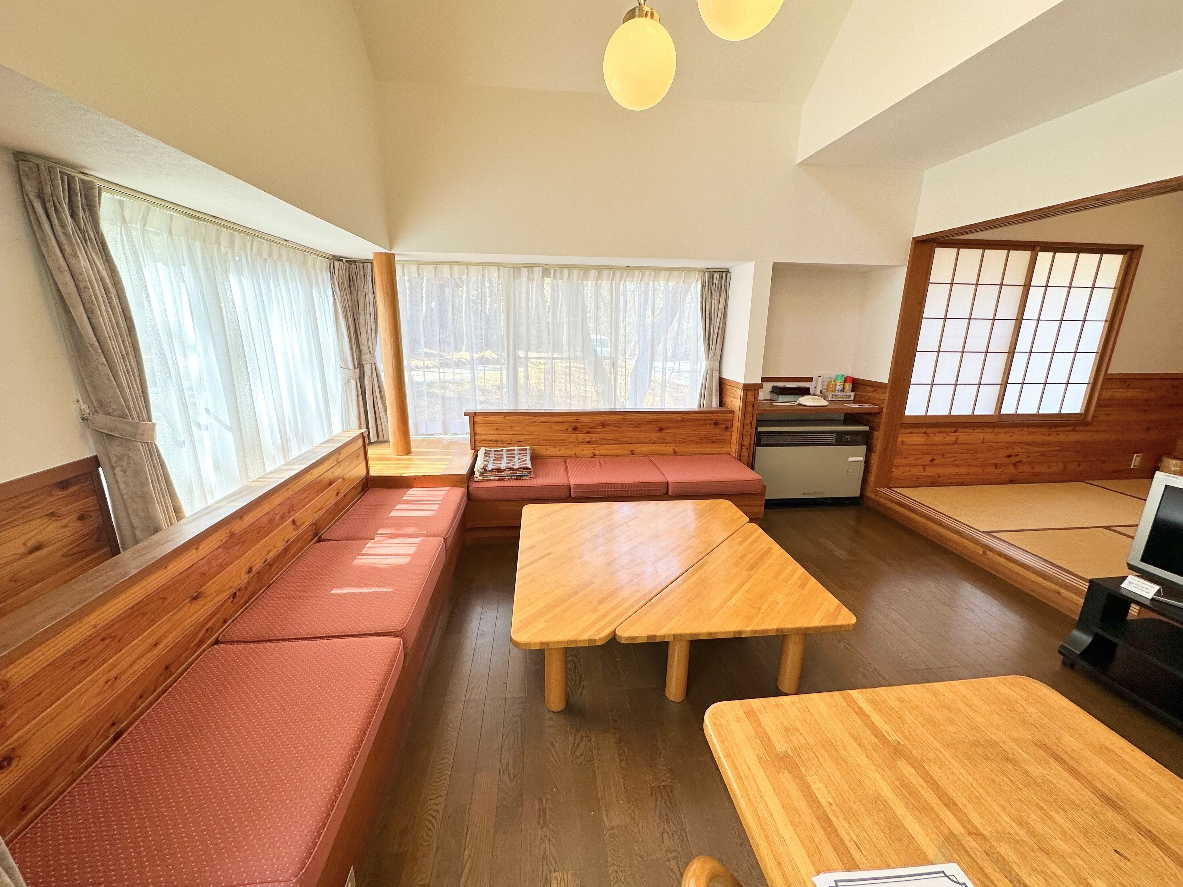 Une pièce de style japonais traditionnel, avec un sol recouvert de tatamis, des meubles en bois et des portes coulissantes.