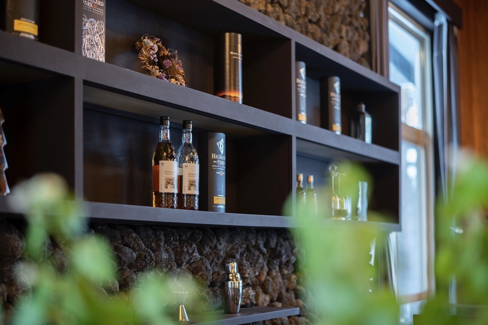 A shelf with various bottles and a decorative item.