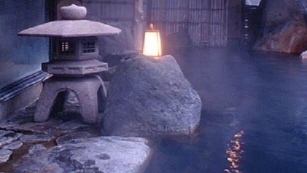 A traditional Japanese onsen with a stone lantern, wooden structures, and a stone bath area. - Kouunsou (Nasushiobara)