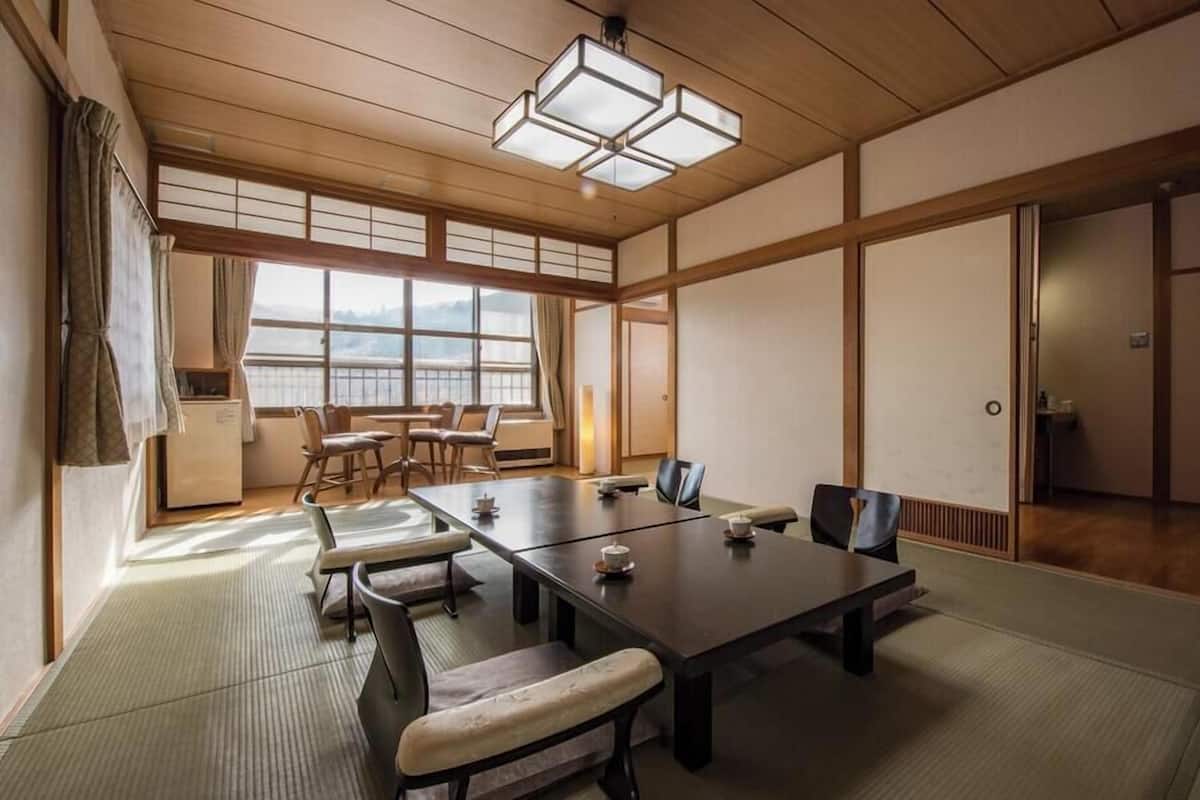 A traditional Japanese-style room with tatami flooring, a low table, and sliding doors.
