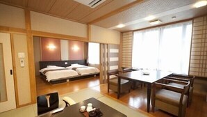 A hotel room with a bed, a dining table with chairs, a TV, and a small table with tea set. - Kouunsou (Nasushiobara)