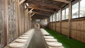 A long, narrow corridor with wooden walls and a central water feature. - Kouunsou (Nasushiobara)