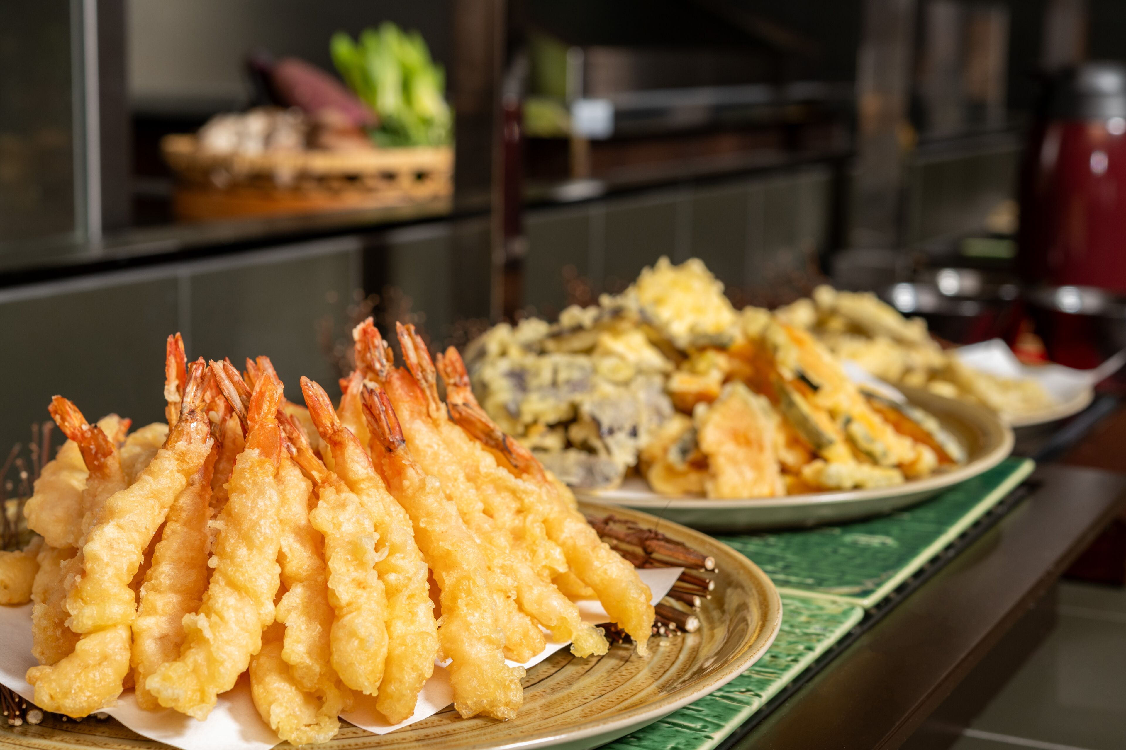 A buffet table with various dishes including tempura shrimp and other fried items.