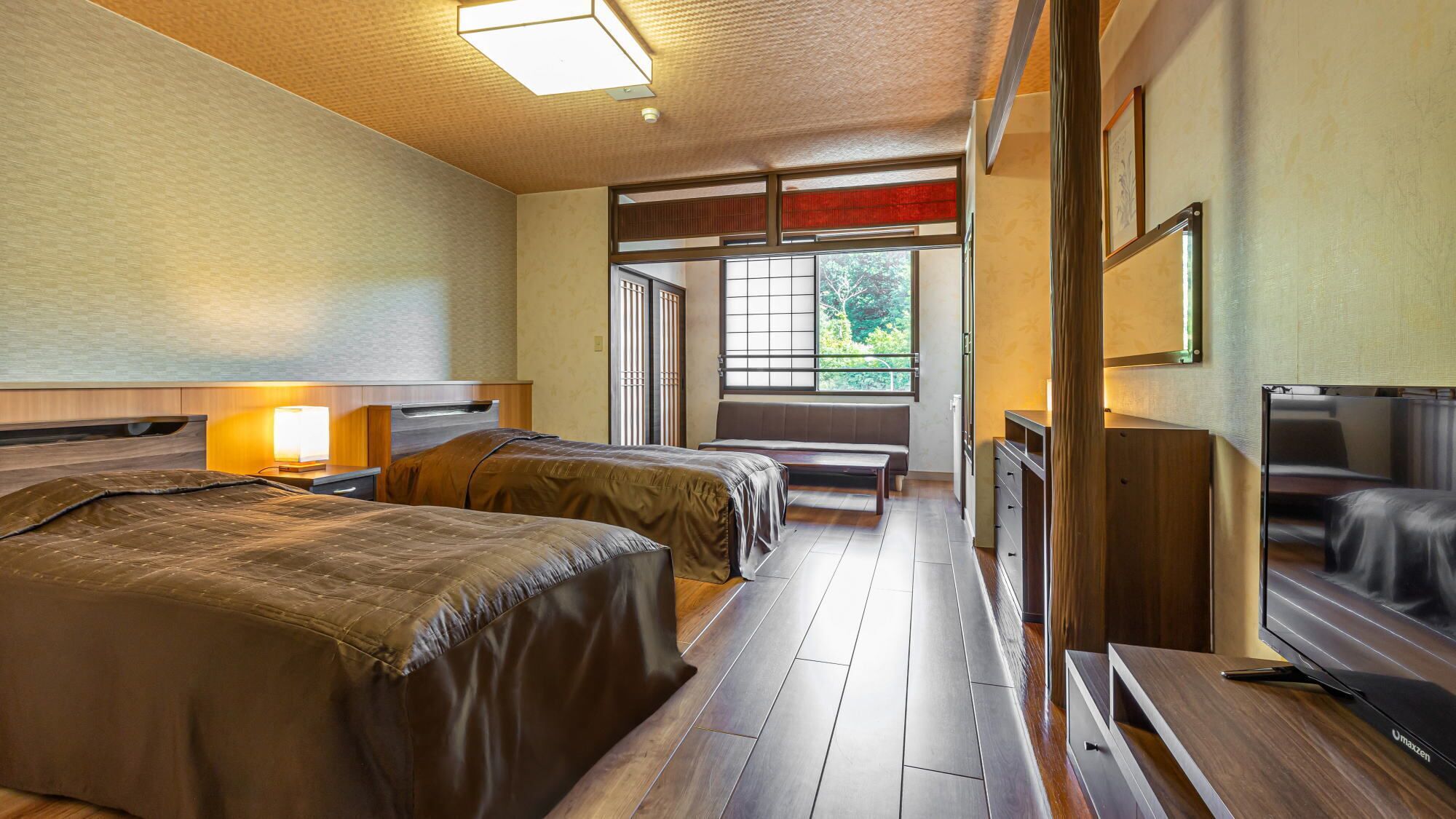 Une chambre d’hôtel avec deux lits, une télévision, un bureau et une fenêtre donnant sur un paysage agréable.