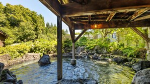 Una estructura de madera sobre un arroyo con rocas y follaje.