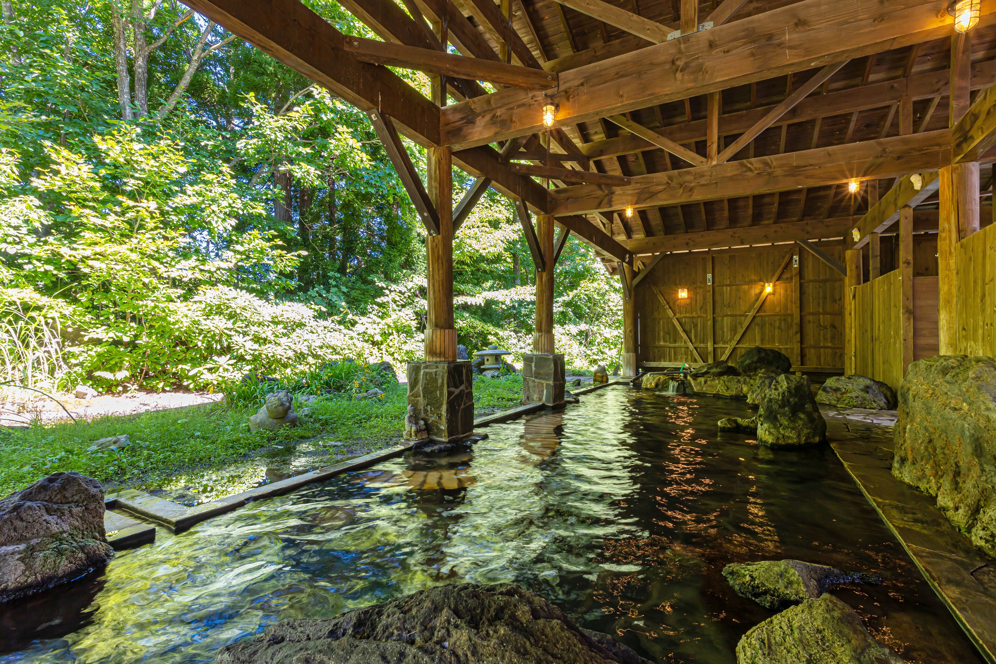 A wooden structure with a water feature, including a clear water path and rocks.