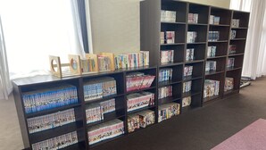 A library with multiple bookshelves filled with books and magazines. - Hotel Hikari Hills (Hikari)