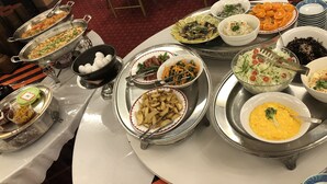 A buffet table with various dishes including pasta, salads, and fruits. - Hotel Hikari Hills (Hikari)
