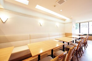 A restaurant interior with high tables, cushioned booths, and wooden chairs. - Inuyama Central Hotel (Inuyama)
