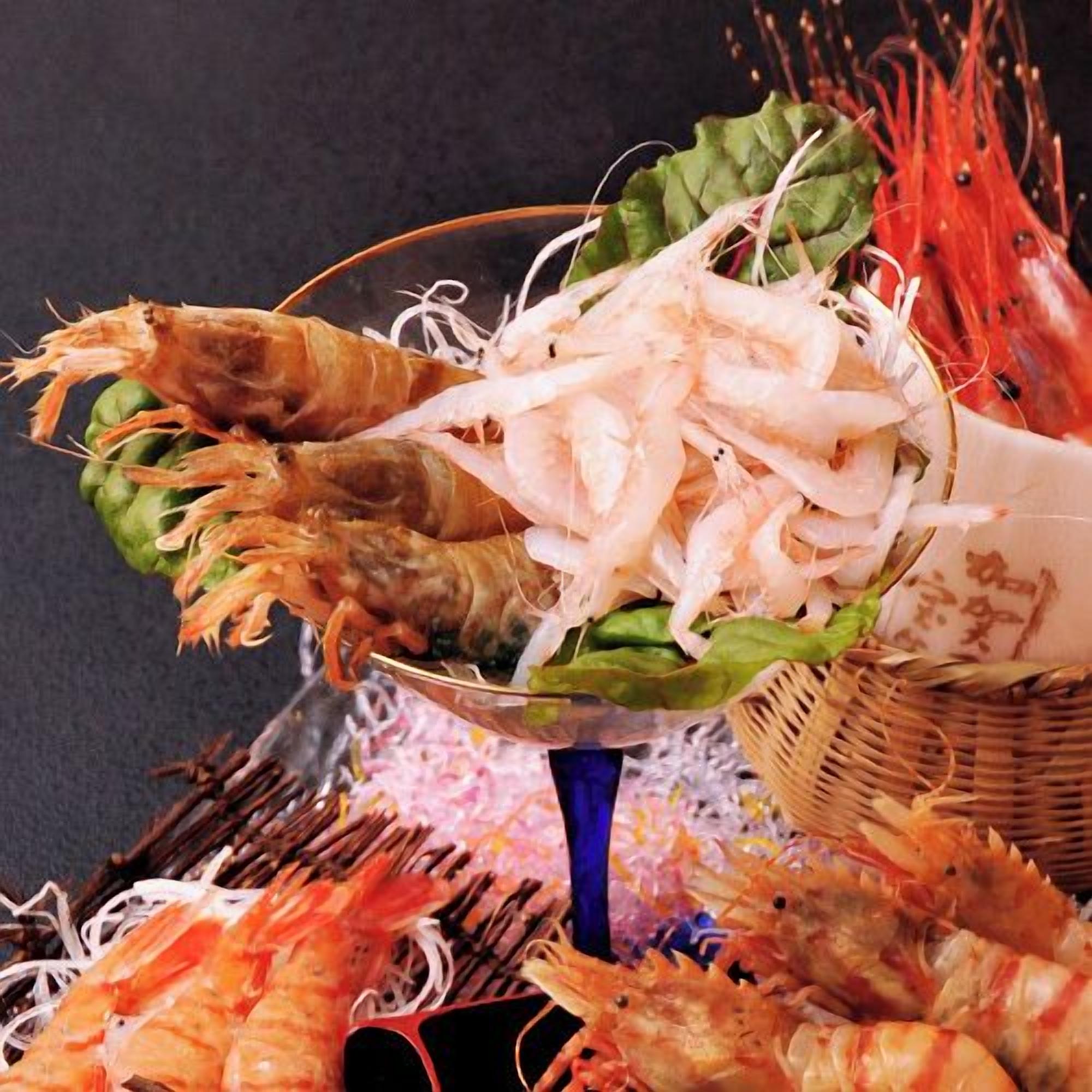 Variedad de mariscos, incluyendo camarones y langosta, dispuesta sobre una mesa.